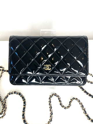Black quilted handbag with chain strap on a white background