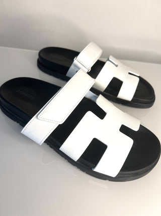 Black and white slide sandals on a light gray background