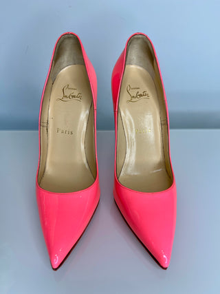 Pair of pink high-heeled shoes with brand logo on a gray background
