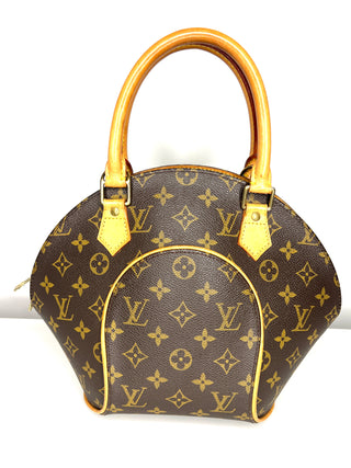 Designer handbag with monogram pattern and gold accents on a white background