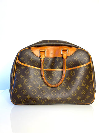 Brown monogram handbag with tan leather handles and trim on a white background