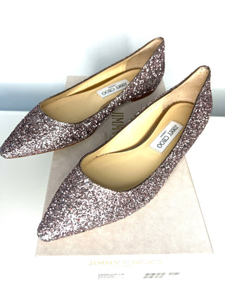 Pair of glittery shoes with a visible brand label on a white background
