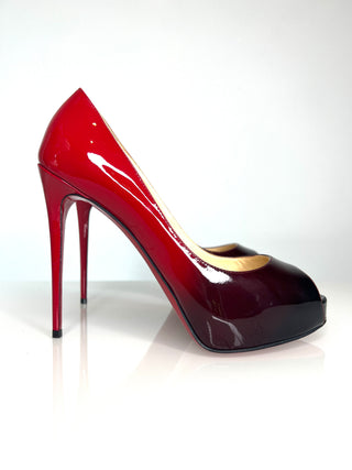 Shiny red  and black ombre high-heeled shoe on a white background