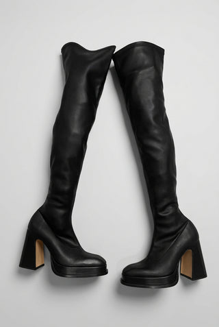 A pair of Souliers Martinez black leather over-the-knee boots with high block heels and platform soles.