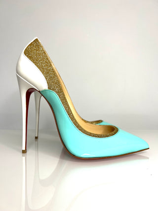 High-heeled shoe with white base, turquoise front, and gold glitter sides on a light gray background