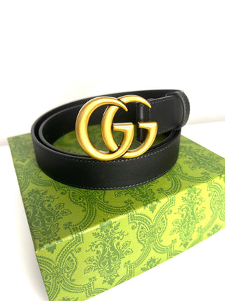 Black belt with gold buckle on a green patterned box