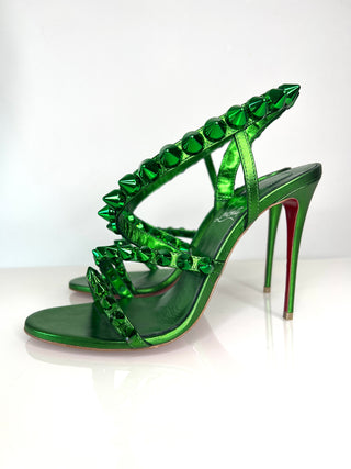 Green high-heeled shoes with studded design on a white background