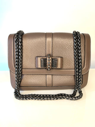 Christian Louboutin Sweet Charity grey pebbled leather shoulder bag with a gunmetal chain strap and a central bow-shaped metal clasp