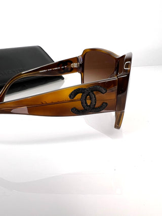 Chanel sunglasses with a black logo on a white background