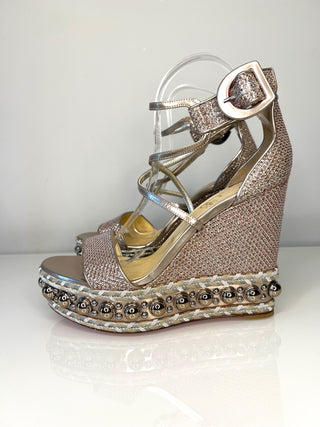 Silver wedge sandal with embellishments on a white background