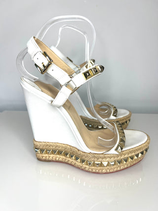 White wedge sandals with clear straps on a white background