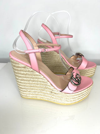Pink wedge sandals with espadrille sole on a white background