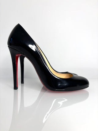 Black high-heeled shoe with red sole on a white background