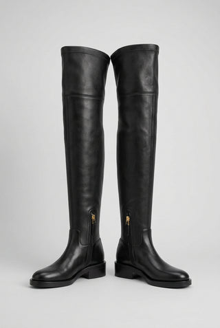 A pair of Valentino Garavani Roman Stud black leather over-the-knee boots with a low block heel and a side zipper.