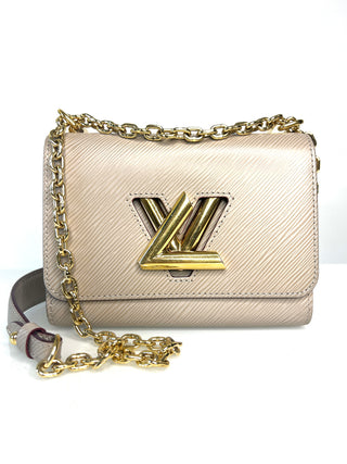 A Louis Vuitton shoulder bag in beige textured leather with a gold-tone chain strap and a prominent gold-tone LV logo twist clasp on the front flap.