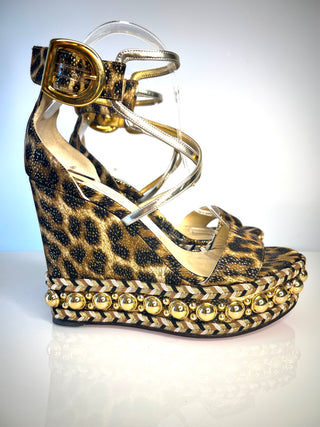 Christian Louboutin Chocazeppa  platform wedge sandal with a leopard print pattern, gold-tone buckled ankle strap, and a braided platform studded with gold beads.