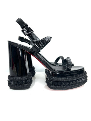 Black high-heeled sandals with raffia straps on a white background