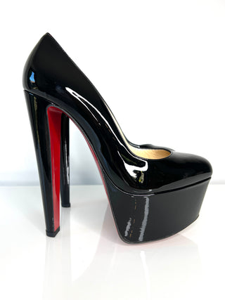 Black high-heeled shoe with red interior on a white background