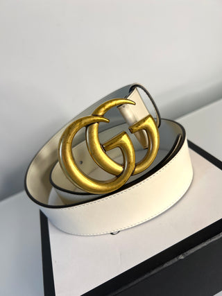 White belt with gold interlocking G buckle on a light gray background