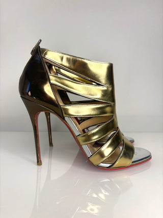Gold high-heeled shoe with a white background