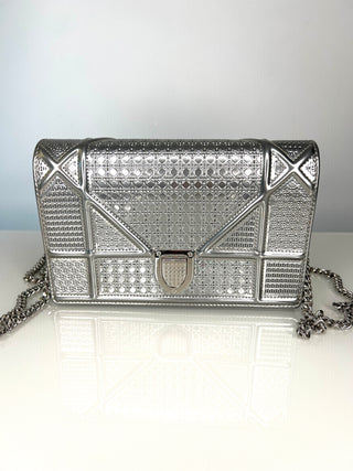Silver metallic clutch bag with geometric design on a white surface