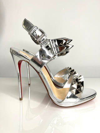 Silver studded high-heeled shoe on a white background