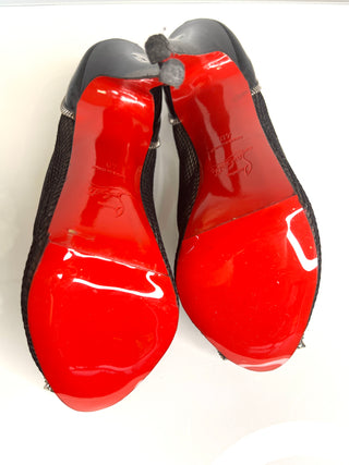 Pair of red shoes with black soles on a white background