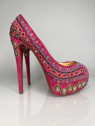 Pink high-heeled shoe with intricate embellishments on a white background
