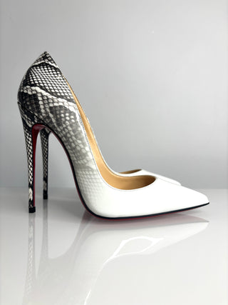 High-heeled shoe with snake print heel on a reflective surface