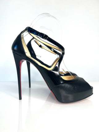 A Christian Louboutin black patent leather high-heeled shoe with a platform sole, cutout straps and red sole