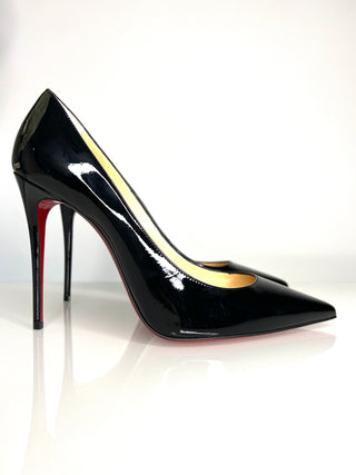 Black high-heeled shoe with a red sole on a white background