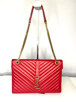 Red handbag with gold chain strap on a white background