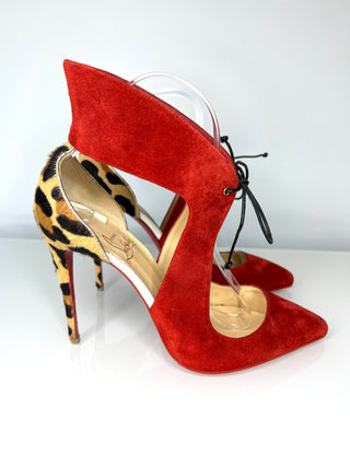 Red high-heeled shoes with a leopard print insole on a white background