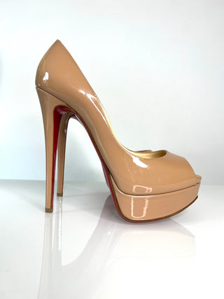 Christian Louboutin Lady Peep high-heeled pump in glossy nude patent leather with platform, peep-toe and red sole.
