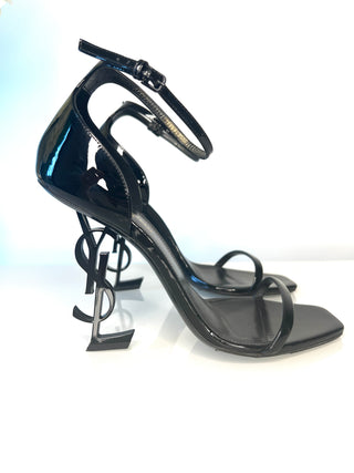 Black high-heeled strappy sandal with unique YSL heel design background