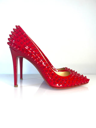 Christian Louboutin Pigalle Spikes bright red patent leather high-heeled pump covered in matching red studs.