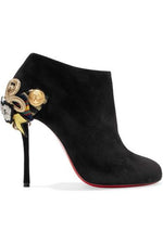 black suede ankle booties with gold medal embellishments and signature red soles